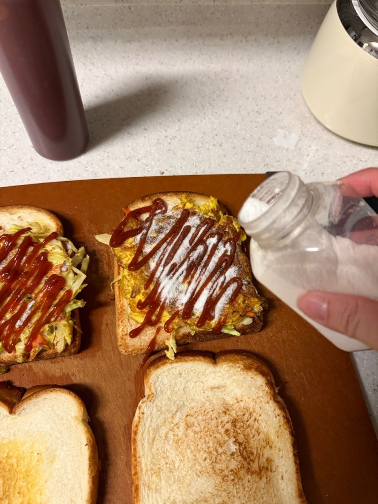 A classic homemade Korean street toast with egg, cabbage, and sugar on a wooden plate.