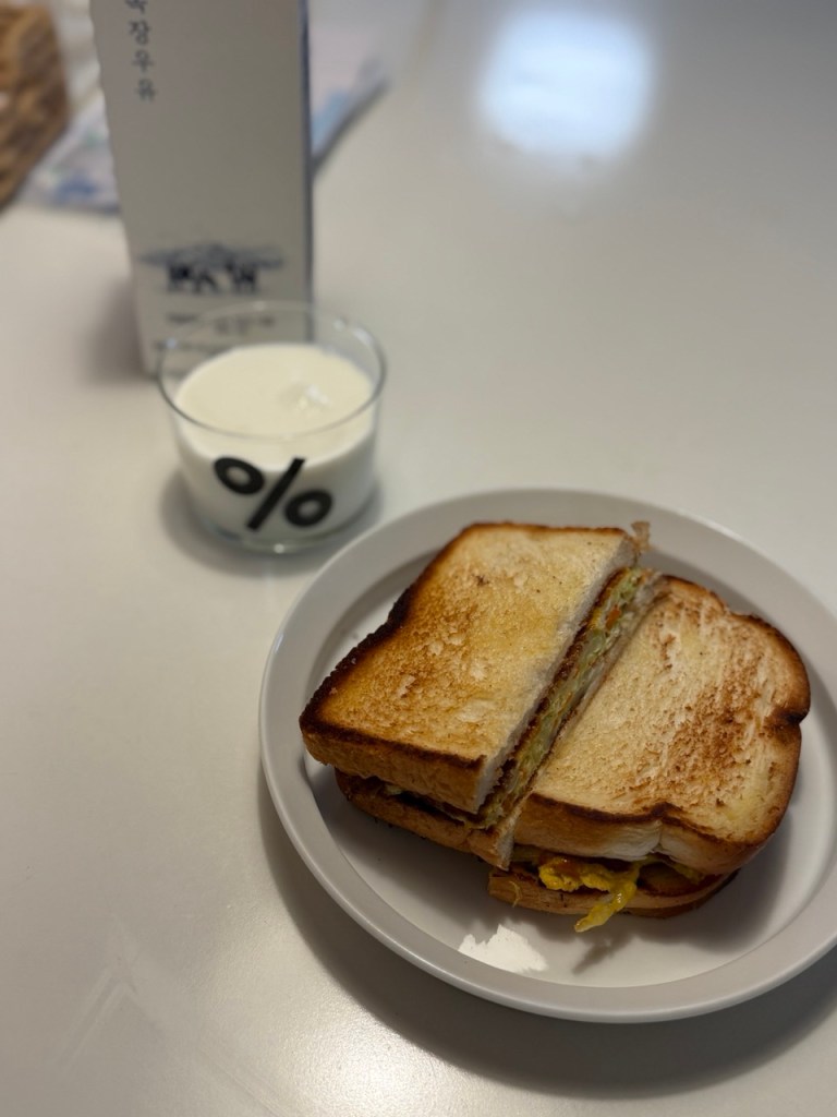 A classic homemade Korean street toast with egg, cabbage, and sugar on a wooden plate.