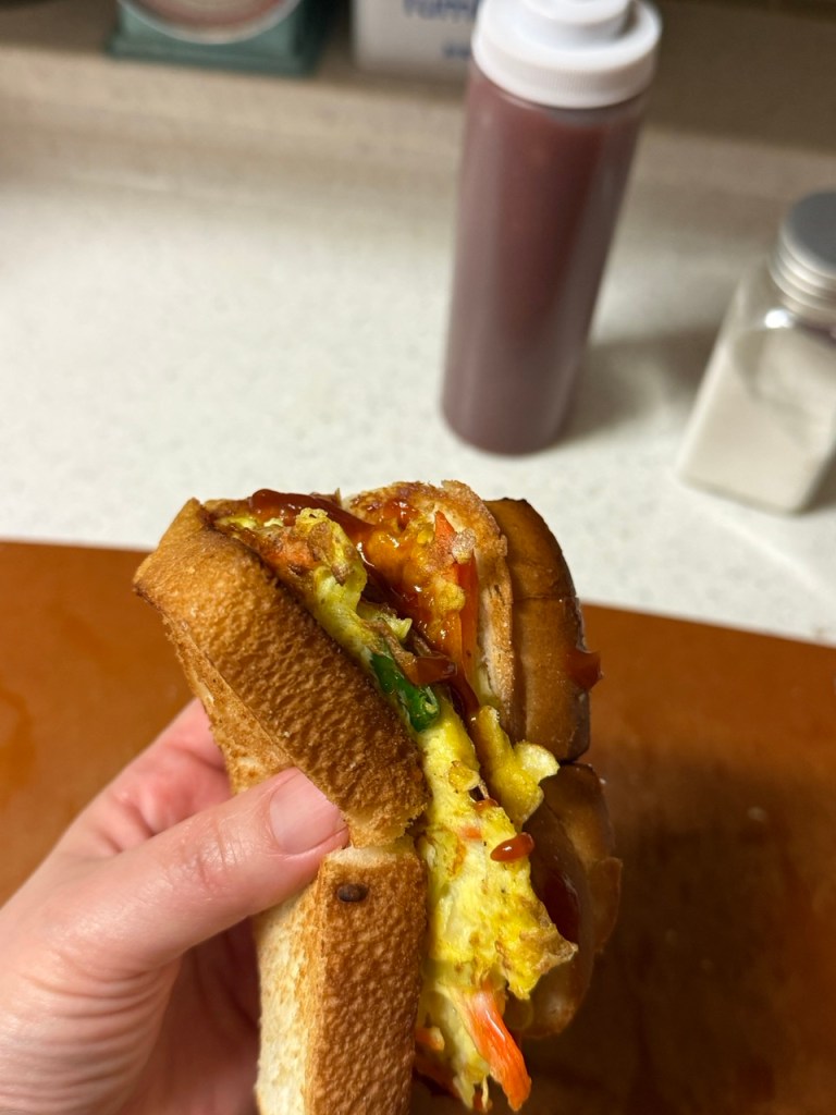 A classic homemade Korean street toast with egg, cabbage, and sugar on a wooden plate.