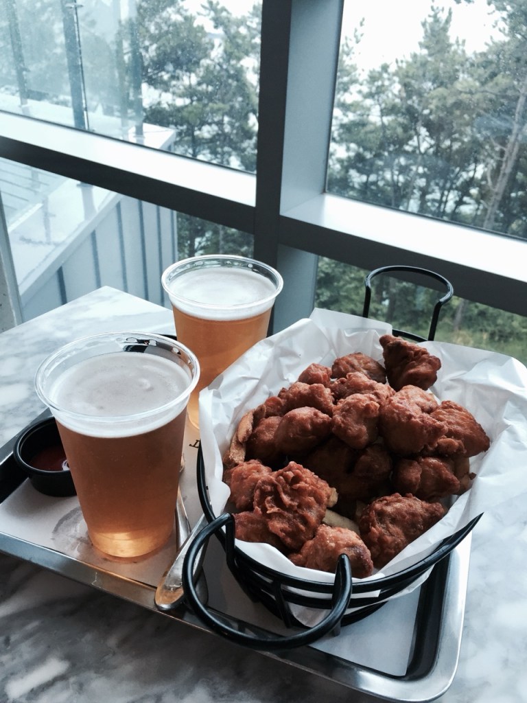A golden crispy fried chicken platter served with a refreshing glass of beer.