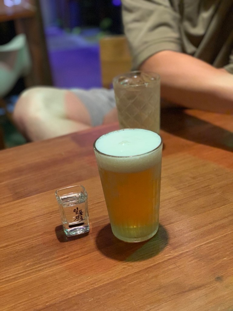 A chilled mug of draft beer with thick white foam on top.