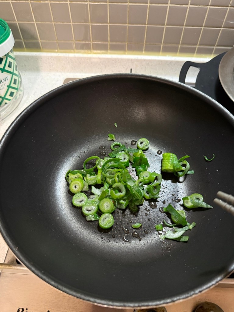Stir-frying chopped green onions first to make a fragrant green onion oil.