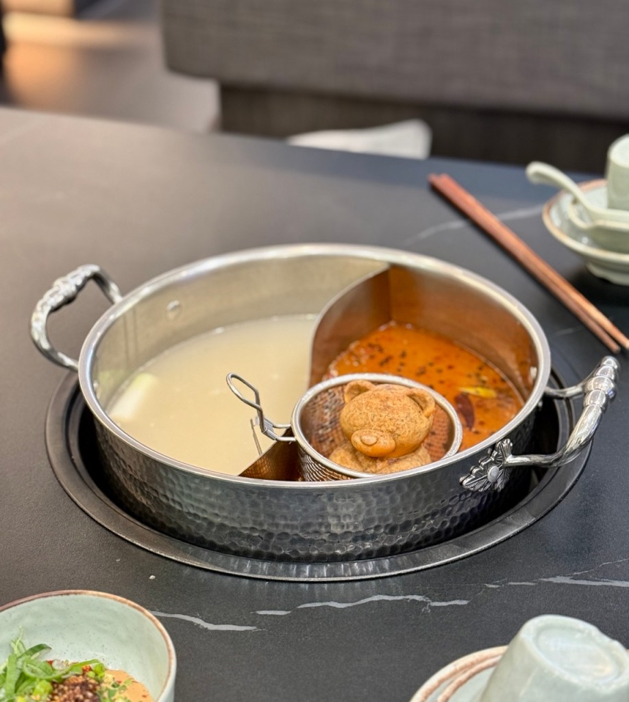 A playful scene of the bear broth appearing to take a bath in the hotpot.