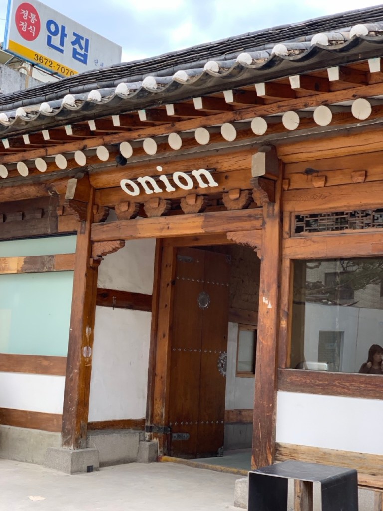 The iconic dark-tiled roof (Giwa) of Cafe Onion Anguk at the entrance.