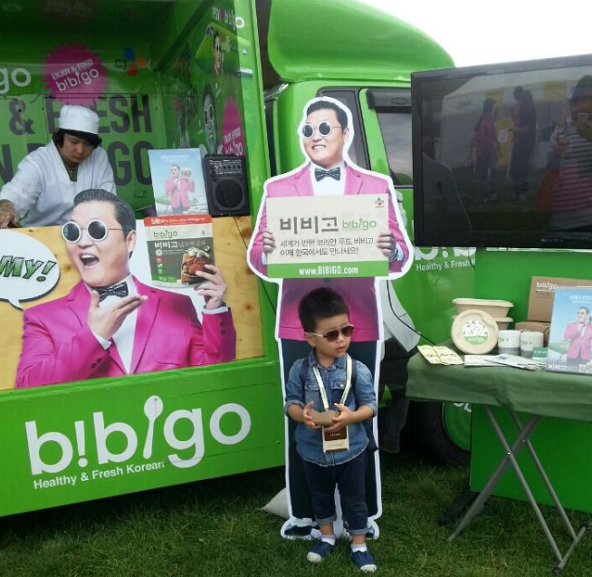 A happy boy holding a bag of Bibigo Mandu for a promotion.