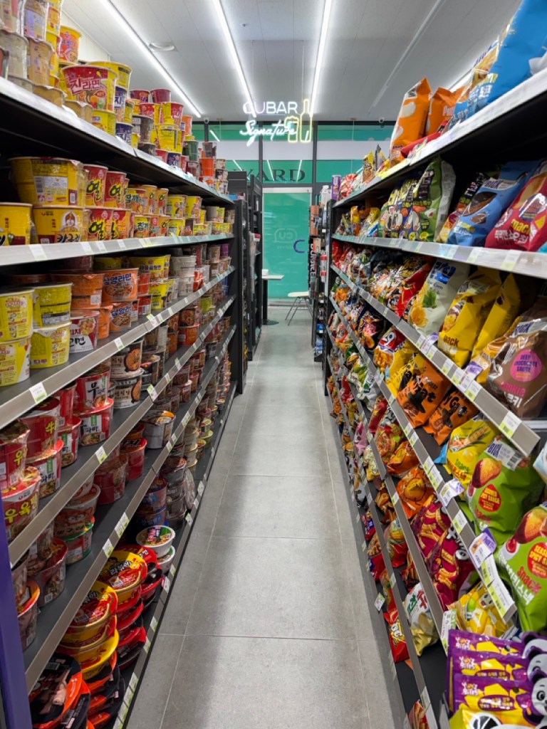 Rows of colorful snack bags and chips displayed on Korea convenience store shelves.