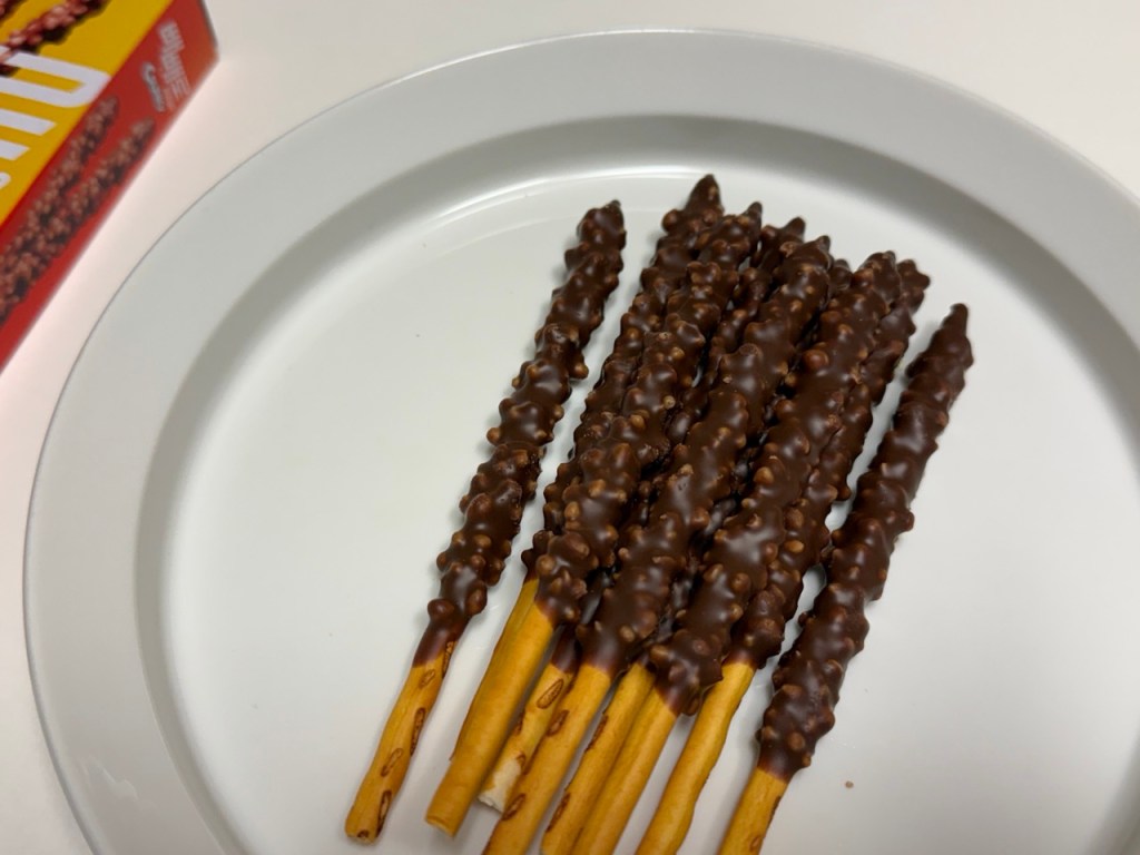 Close-up of Pepero sticks coated with chocolate and crispy malt puffs.