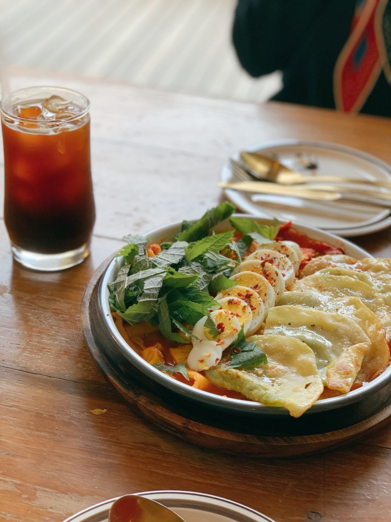 Artistically plated gourmet Tteokbokki with premium toppings in a stylish restaurant.