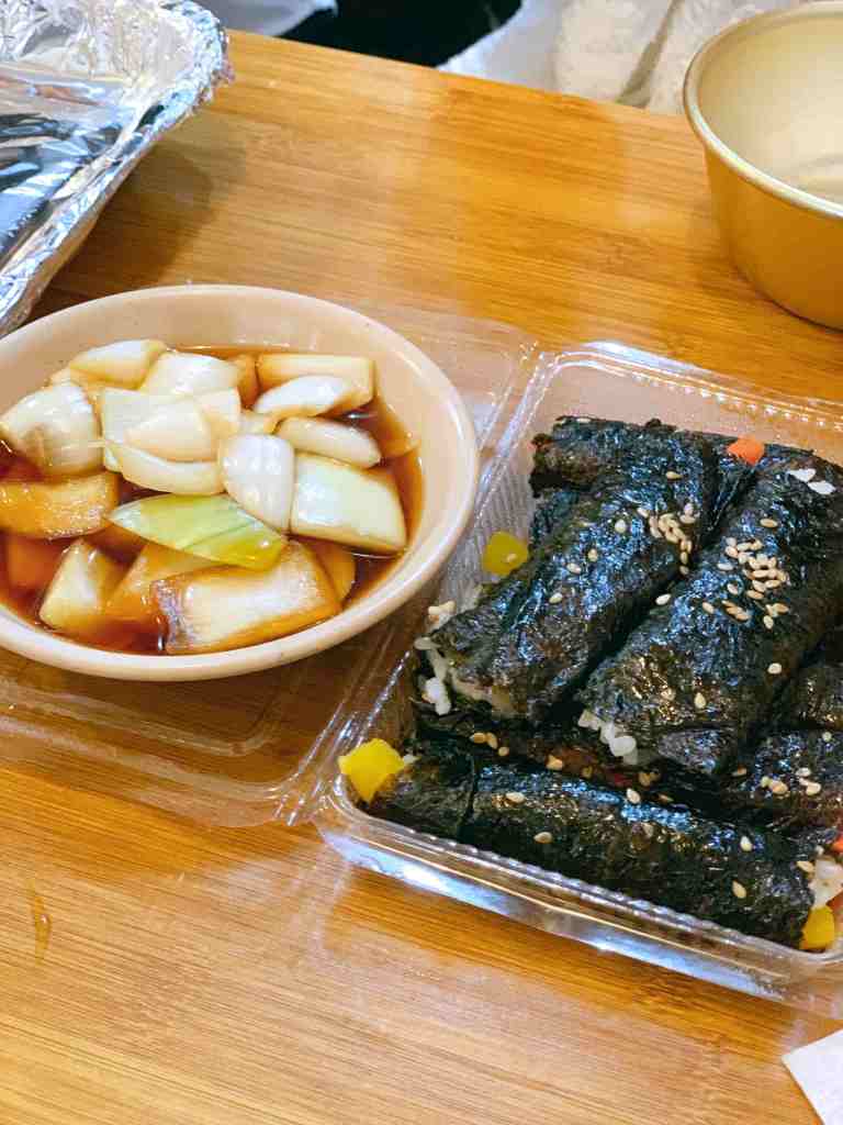 A plastic container filled with Mayak Gimbap, ready for a quick snack or takeout.