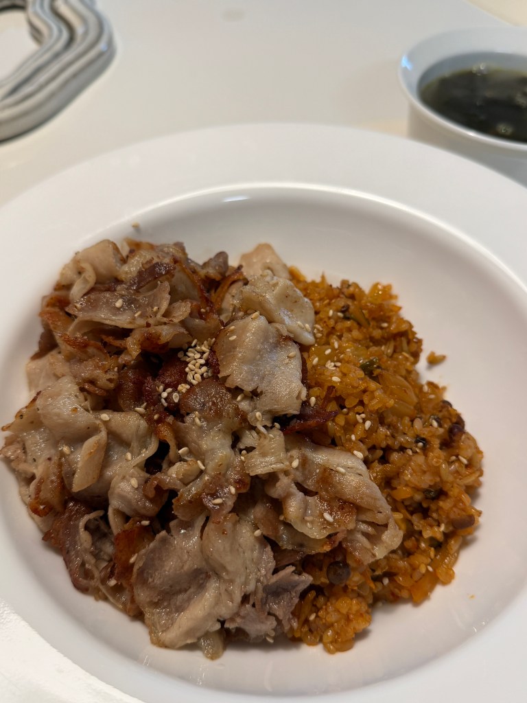 A delicious plate of Kimchi fried rice topped with pork belly