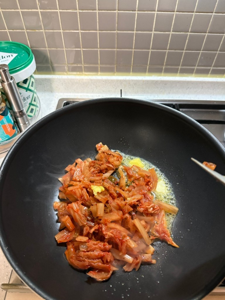 Stir-frying well-fermented Kimchi with a touch of sugar and red pepper flakes.