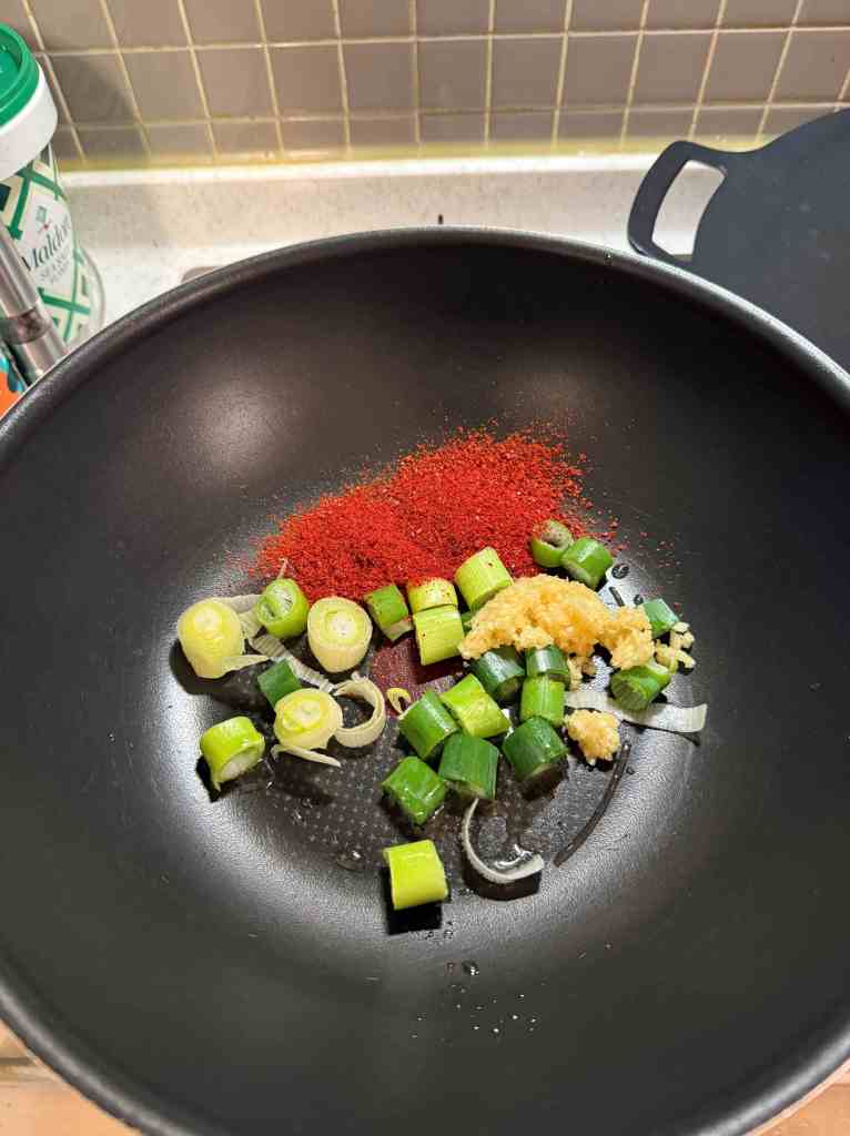Arranging dumplings, vegetables, and glass noodles neatly in a pot.