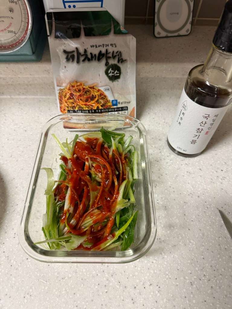 Thinly shredding green onions into long strips using a knife or a green onion slicer.