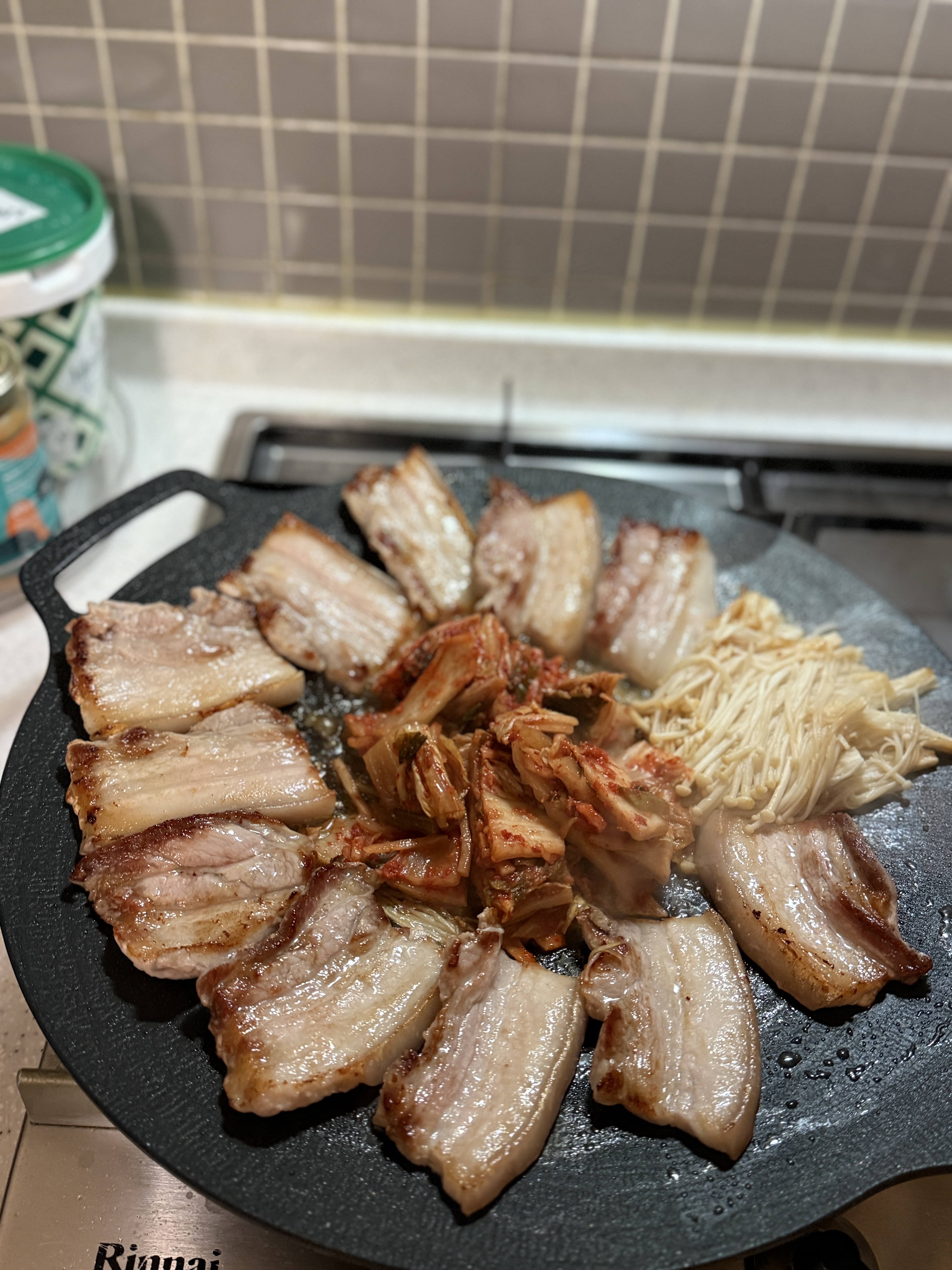 A full Korean BBQ table set up at home with grilled pork belly, kimchi, and side dishes.