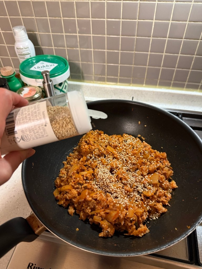 Kimchi fried rice sprinkled with roasted seaweed and sesame seeds.