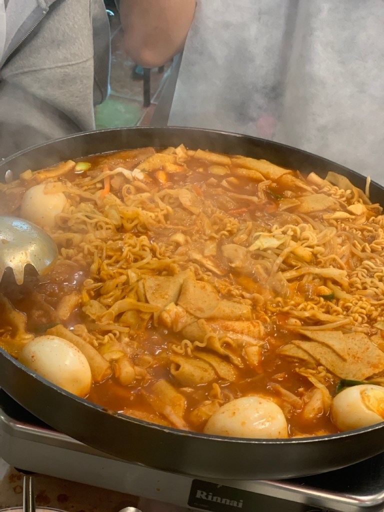 Close-up of savory tteokbokki simmering at the table, a signature experience in Sindang-dong.