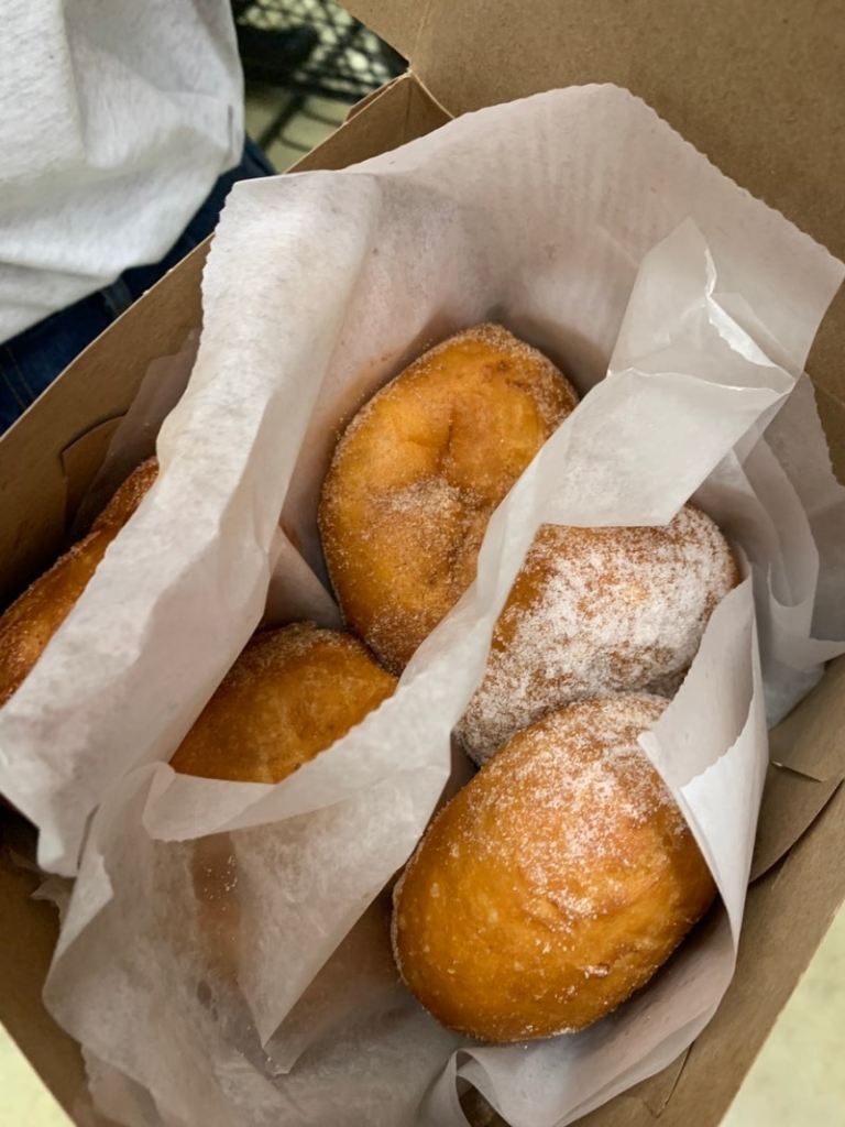 Classic malasadas coated with a generous layer of granulated sugar.