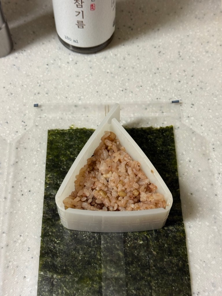 Shaping the rice using a triangle-shaped mold.