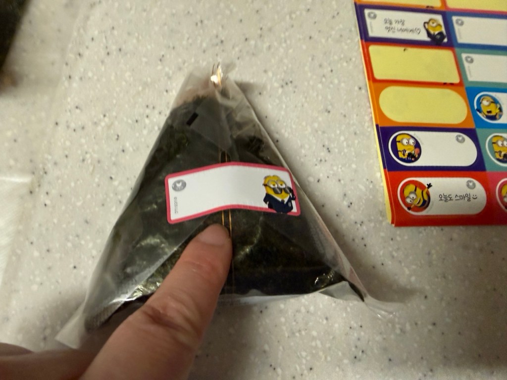 Wrapping the rice with a sheet of dried seaweed.