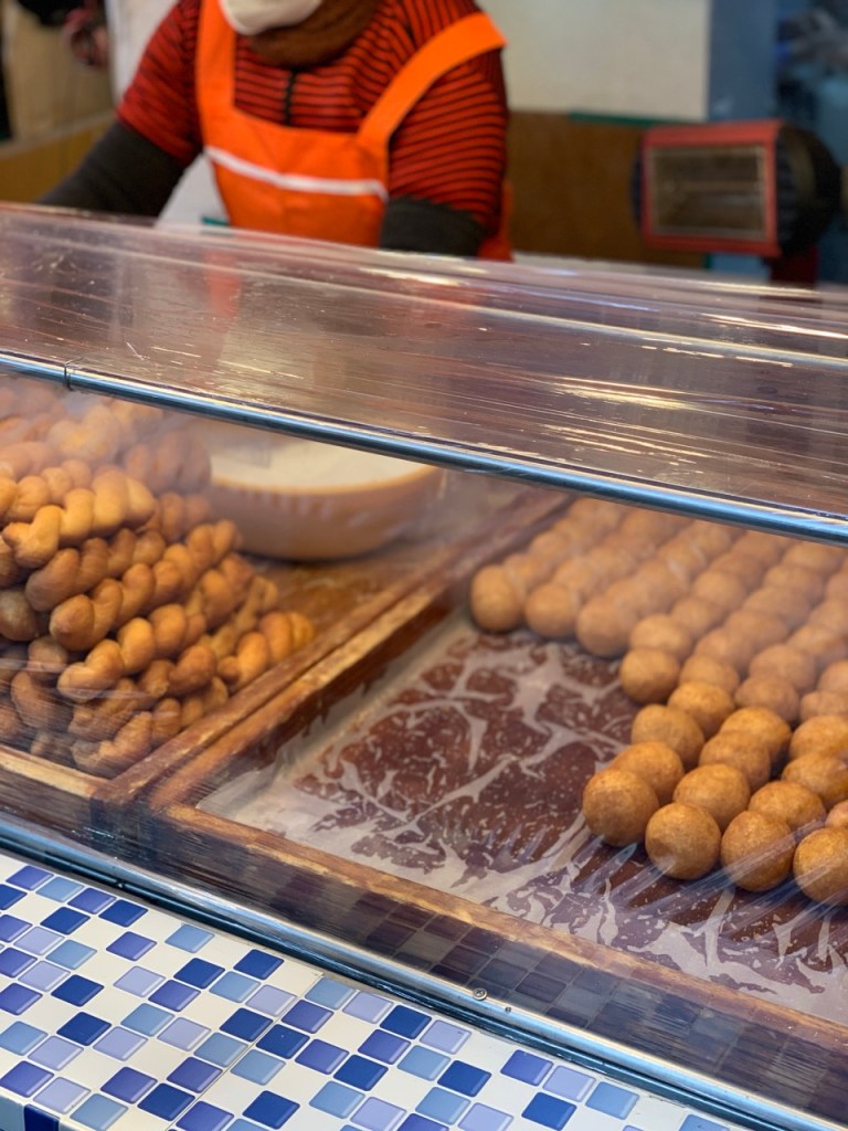 Golden yellow twisted donuts made with chewy glutinous rice or corn flour.