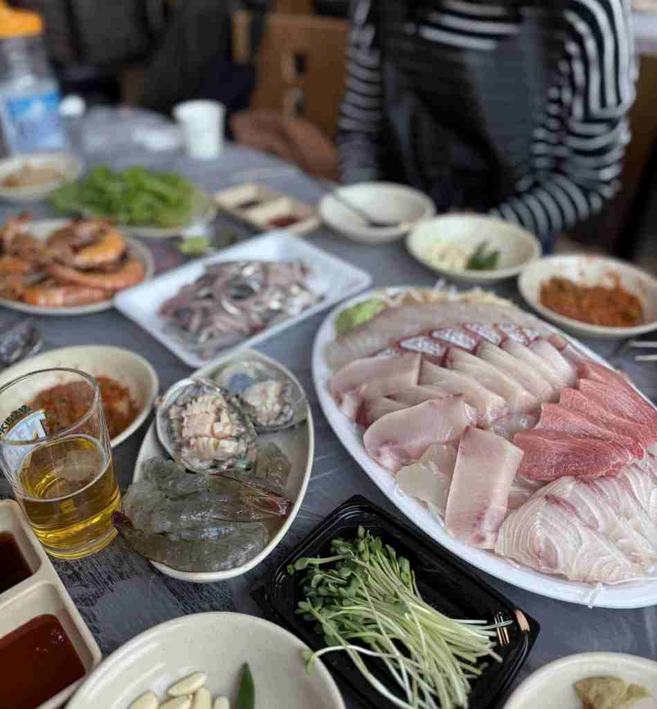 A colorful platter of freshly sliced seasonal sashimi, including salmon and flatfish.