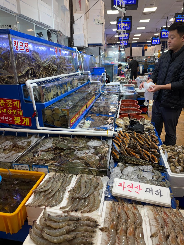 A friendly interaction between a fishmonger and a customer picking out seafood.