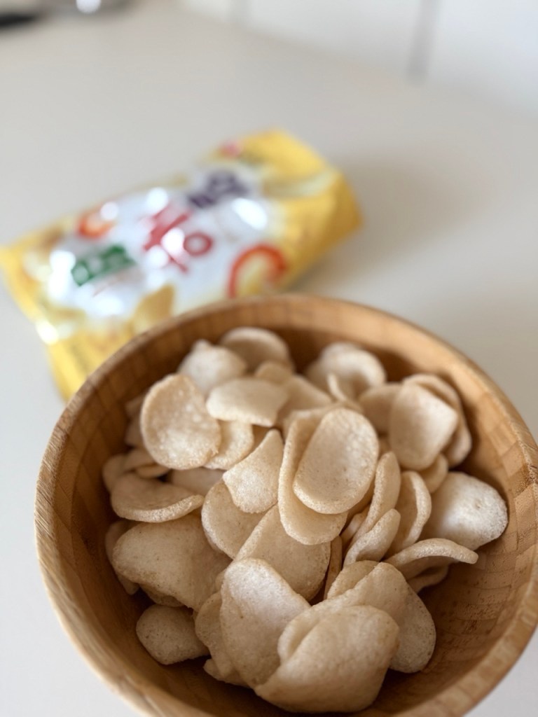 A large plate filled with white and crispy shrimp crackers for sharing.