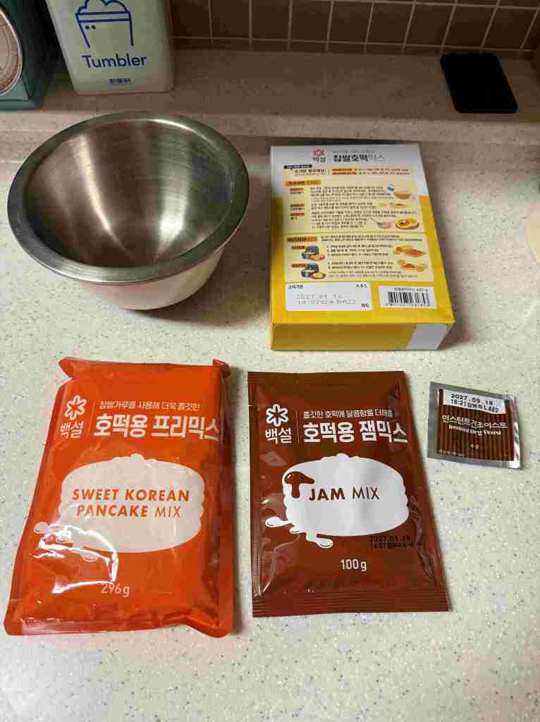 All the necessary ingredients for making homemade Hotteok laid out on a table.