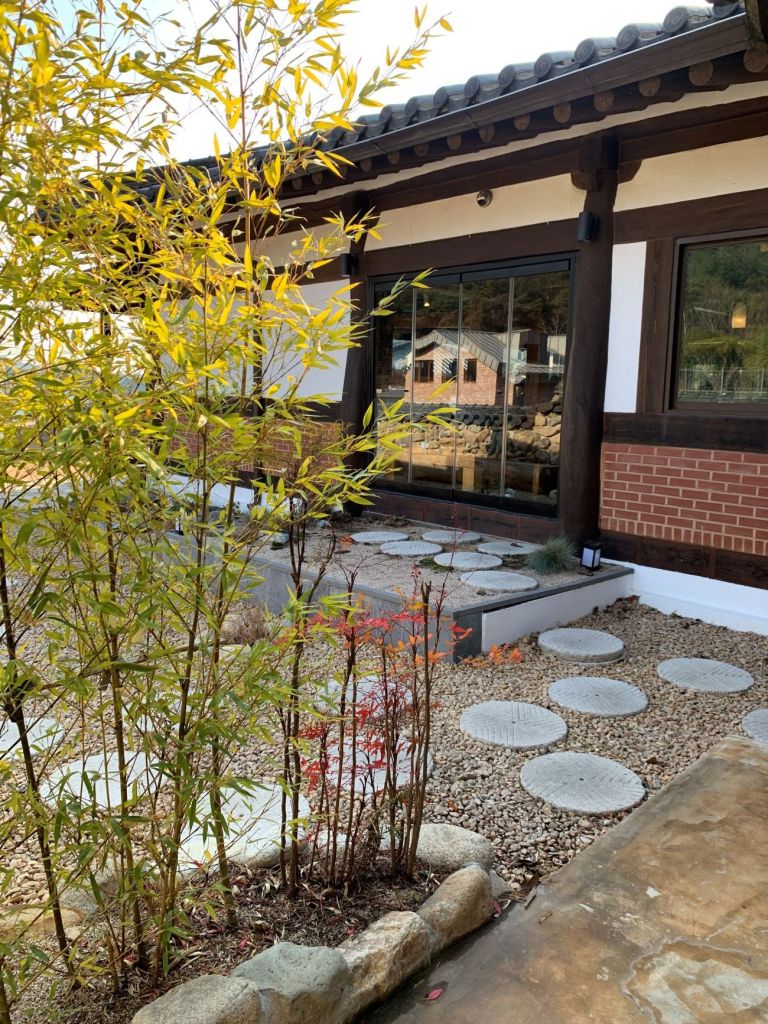 A scenic stone wall path and bamboo trees surrounding the cafe.