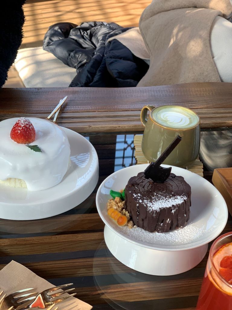 An aesthetic wooden tray featuring colorful Korean rice cakes and treats.