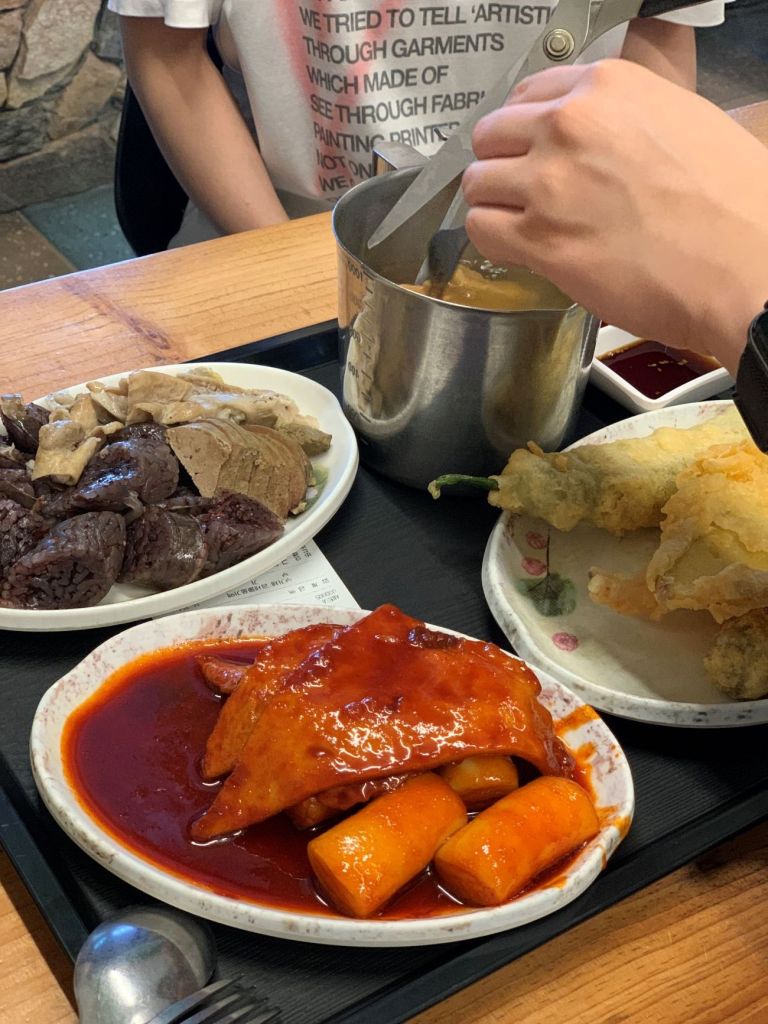 A delicious combination plate of spicy rice cakes and assorted fried snacks.
