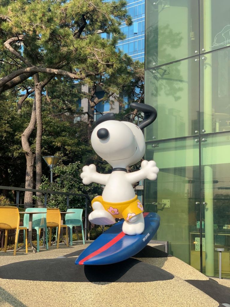 A giant Snoopy figure on a surfboard welcoming guests at the entrance.
