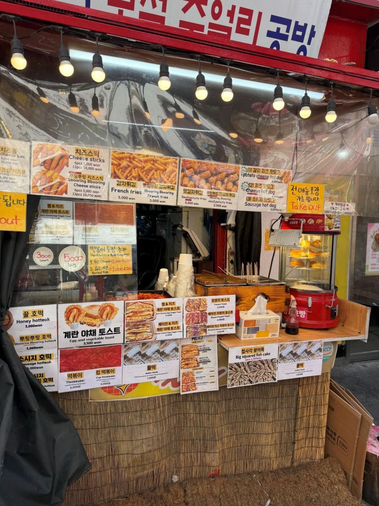 A mouth-watering spread of Hongdae's iconic street foods including fries and tteokbokki.