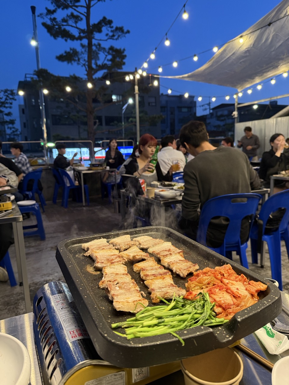 A moody shot of a blue plastic table set up on the street during golden hour.