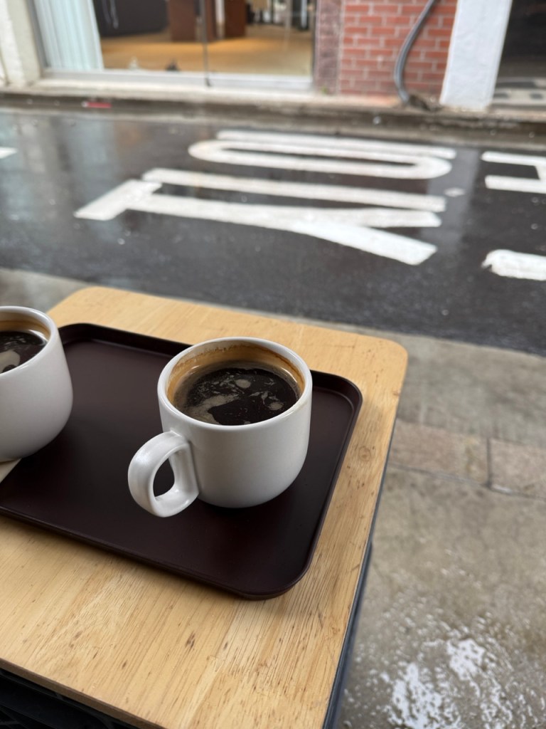 A thick chocolate chip cookie paired with hot coffee for the ultimate rainy day treat.