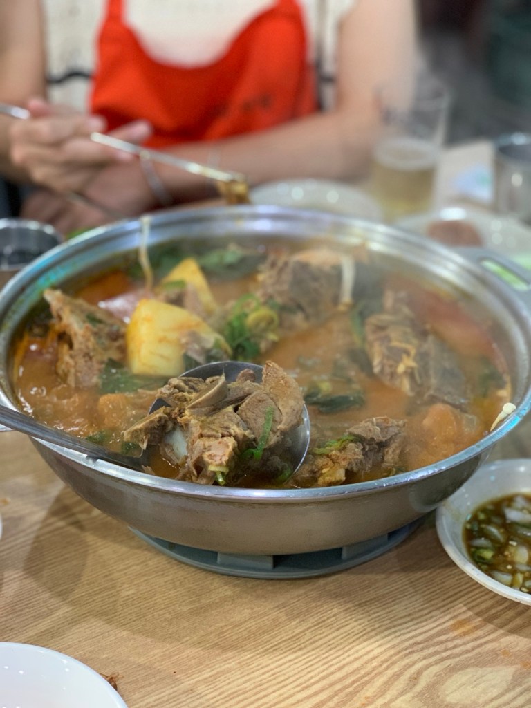 A dynamic shot of the rich, spicy red broth simmering on the table stove.