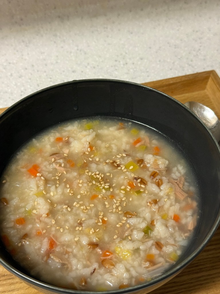 Tuna porridge simmering gently in a pot until the texture is soft and creamy.