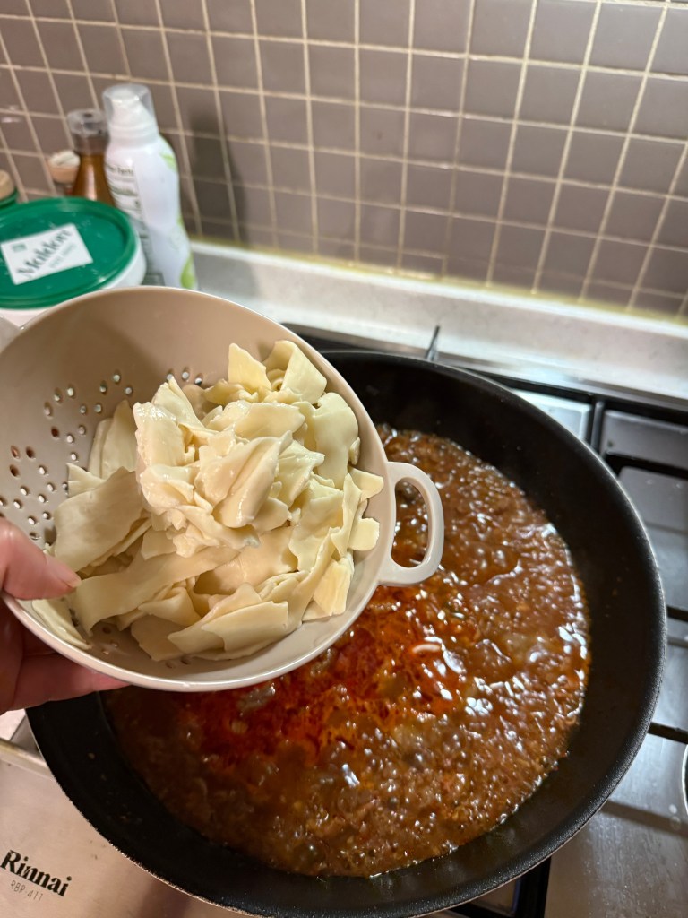 Tossing fresh, sweet napa cabbage into the bubbling spicy pork soup to add natural sweetness.