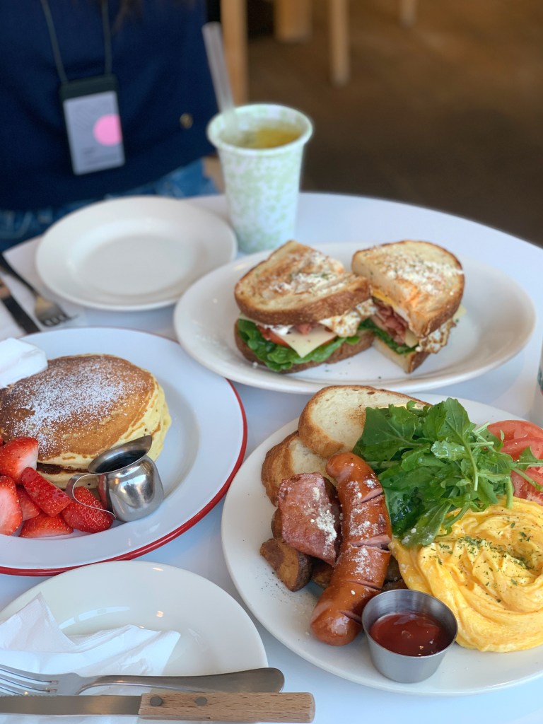 A beautifully arranged morning brunch spread featuring premium egg dishes, fresh salad, and hot coffee.