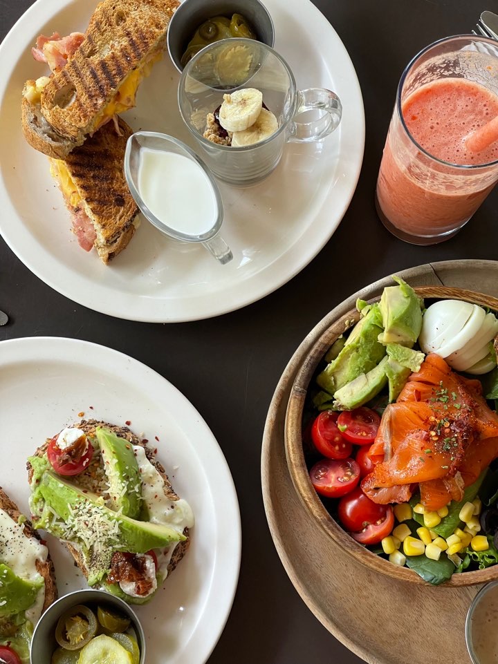 A vibrant and delicious weekend brunch spread featuring hot paninis, fresh salads, and refreshing drinks at Chedda and Oli.