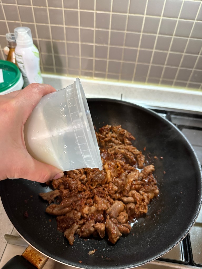 Pouring water and boiling the savory pork cutlet style soup with a rich red chili seasoning.