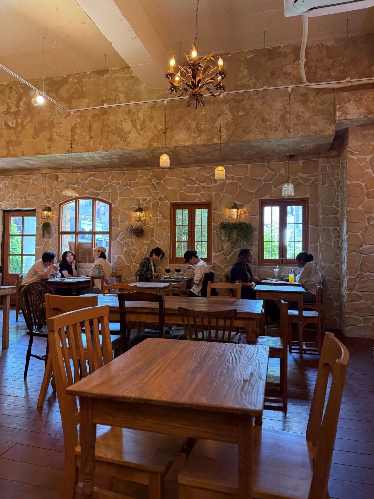 The warm, sunny, and beautifully curated dark wood interior design of Cafe OATT, creating a relaxing ambiance.