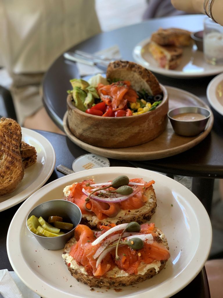 Beautifully arranged open-face sandwiches topped with fresh avocado, seasoned shrimp, and cherry tomatoes.