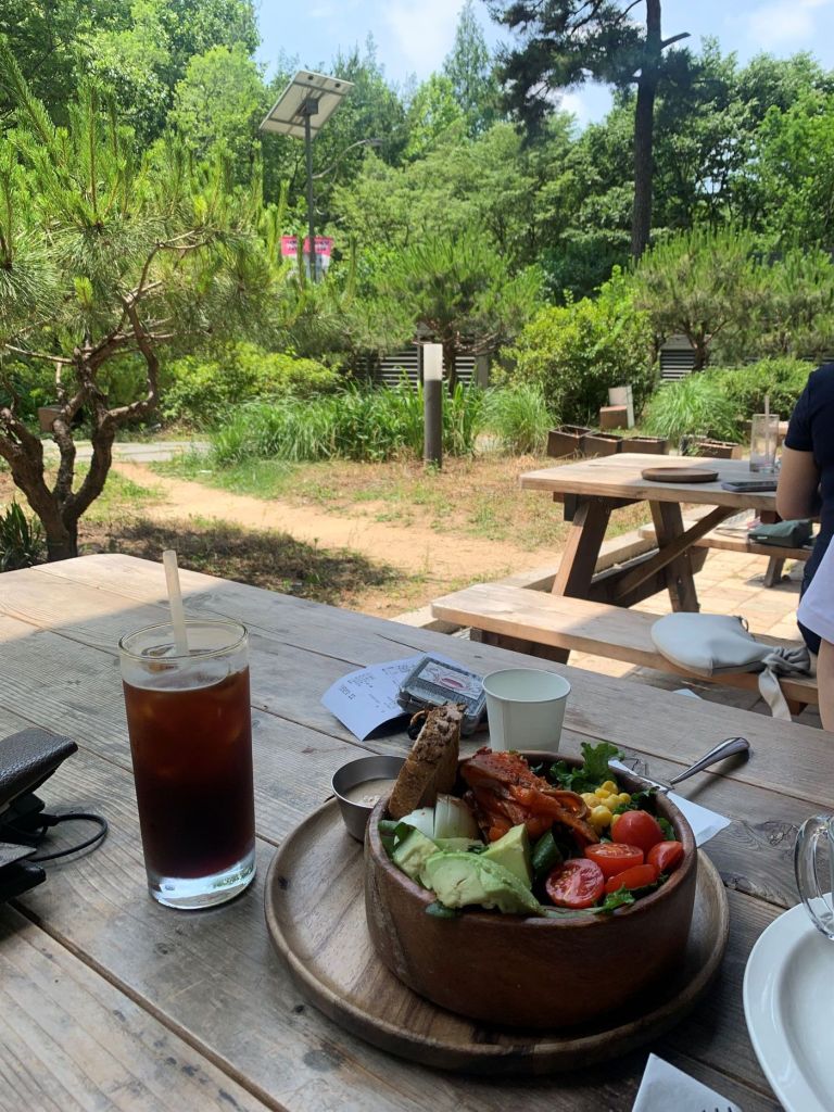 The inviting and trendy outdoor terrace seating of Chedda and Oli cafe, located right next to the scenic Seoul Forest park.