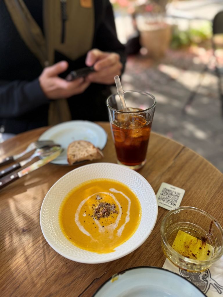 A relaxing midday dining setup with a glass of crisp natural wine paired with a savory brunch dish at Friends and Yard.