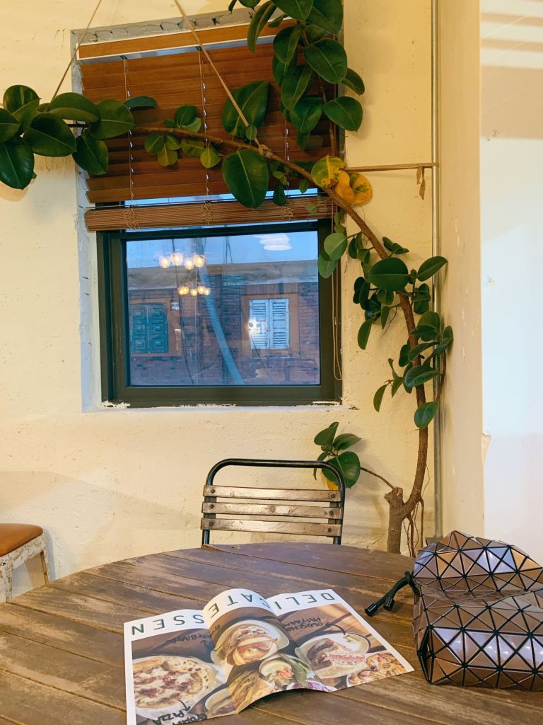 The cozy interior of GOAT DELI Mullae featuring vintage wooden furniture and warm ambient lighting.