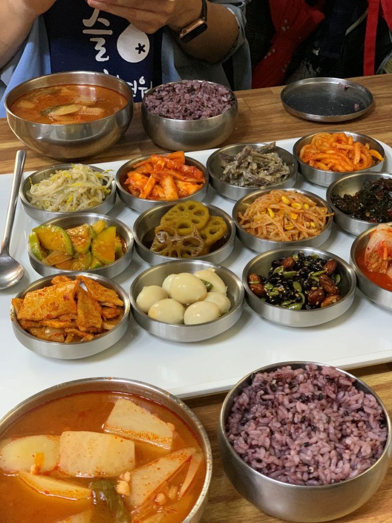 A full spread of Korean baekban with rice, soup, and a variety of traditional side dishes (banchan).