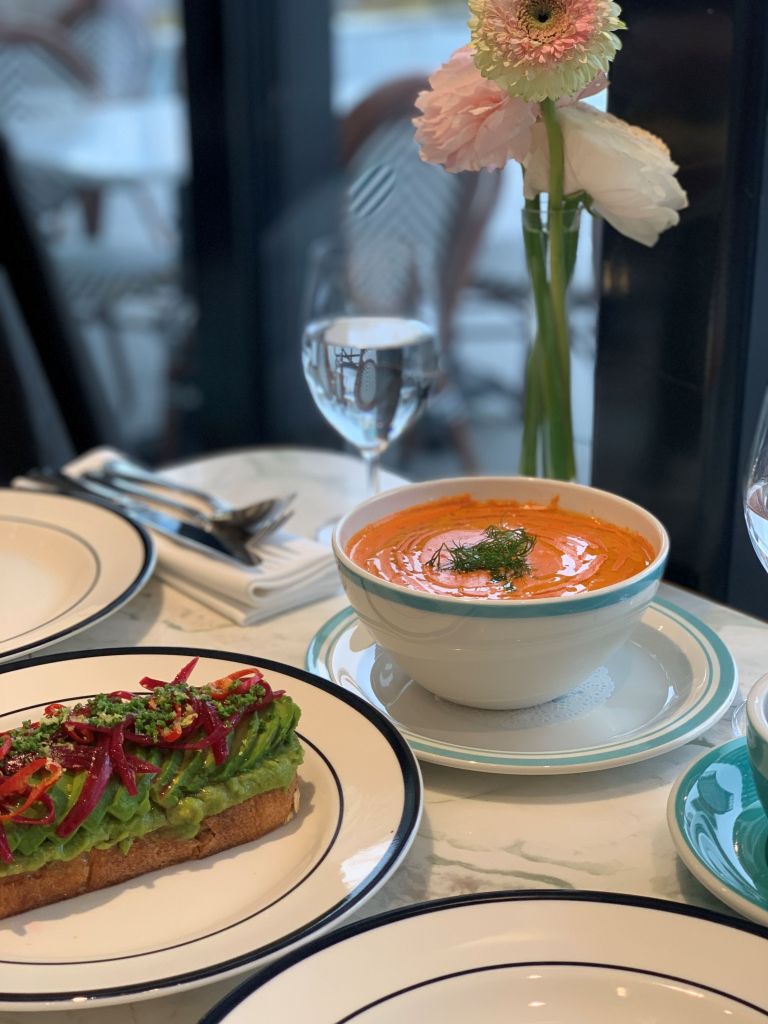 A steaming, rich, and comforting bowl of gourmet tomato soup served with a elegant spoon at Sadelle's Seoul.