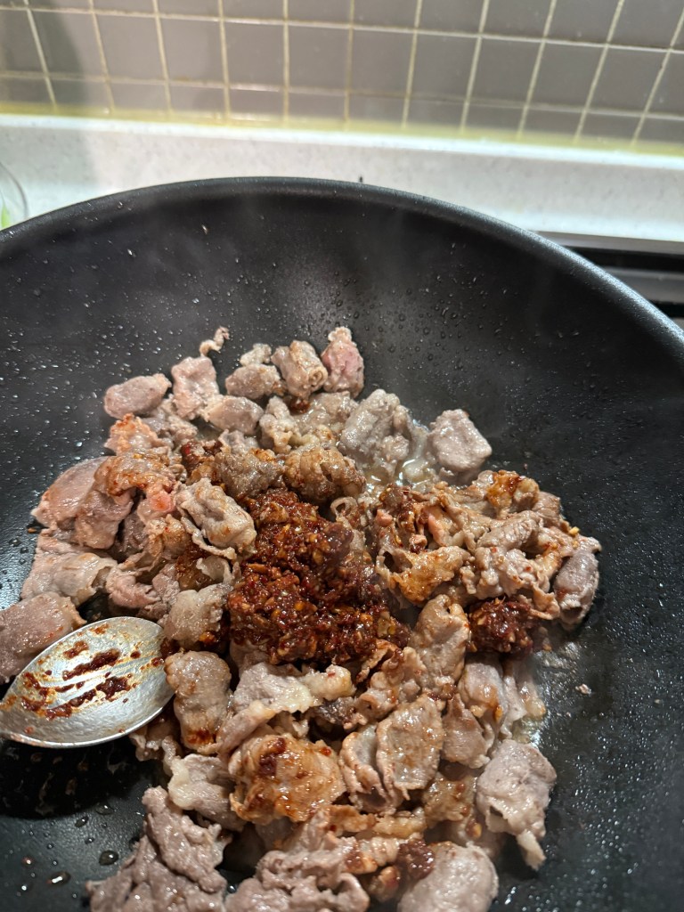 Pouring water and boiling the savory pork cutlet style soup with a rich red chili seasoning.