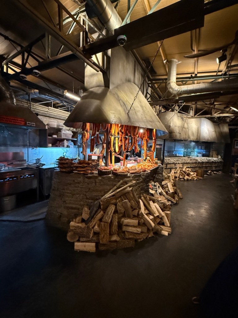 Whipping up a rich, smoky flavor profile as fresh chicken pieces are grilled directly over hot charcoal inside the open kitchen.